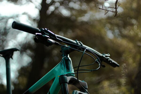 Detailed close-up of a mountain bike handlebar in a natural outdoor setting.